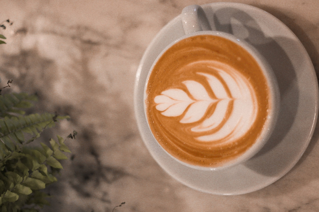 a cup of coffee with a leaf pattern on it