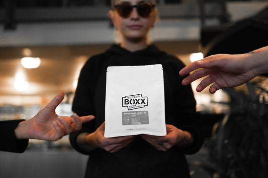 A group of people standing around each other holding a box