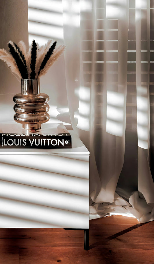 Vase with pampas grass on louis vuitton book.