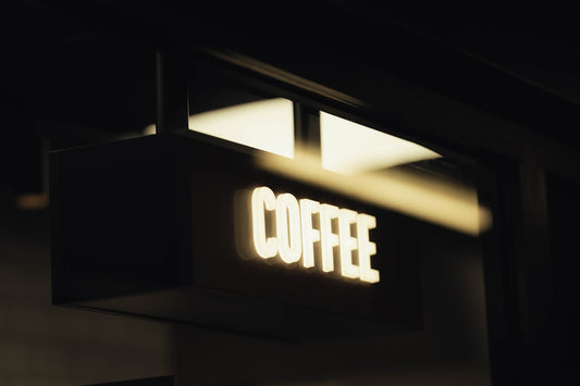 A glowing coffee sign at night