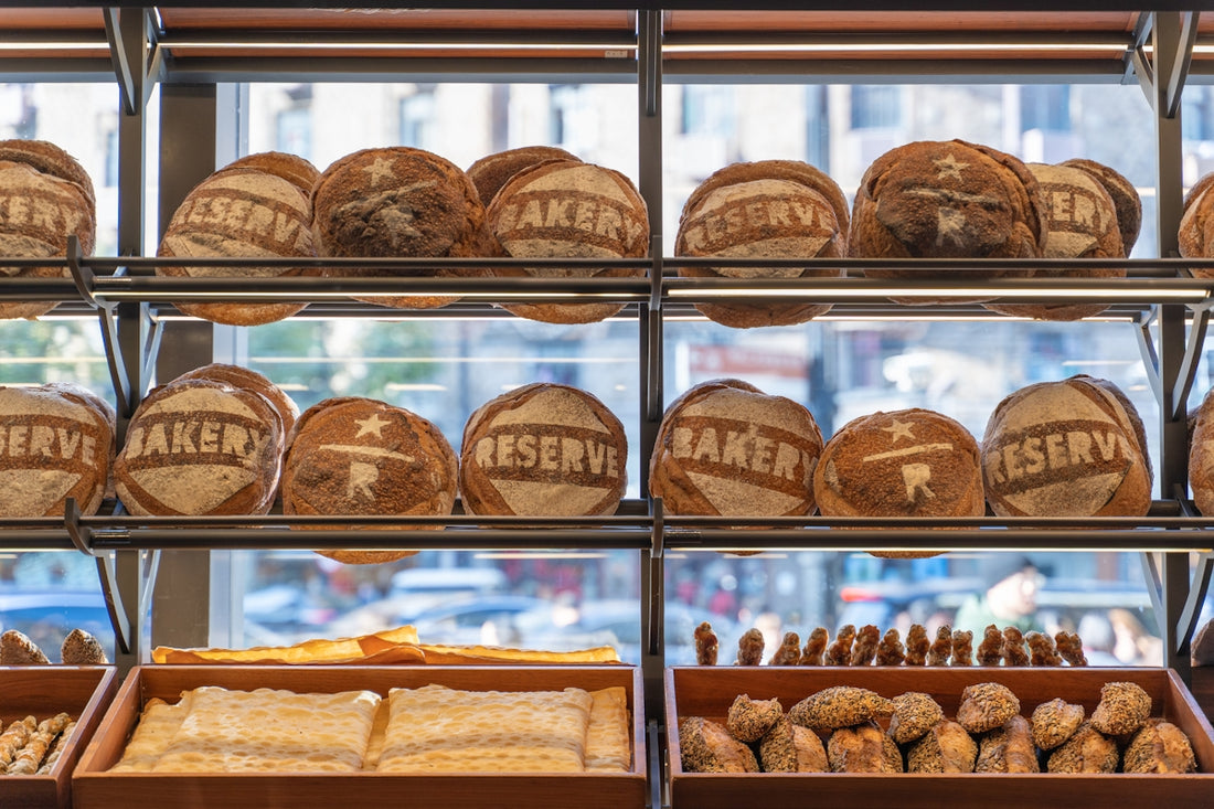 Loaves of bread displayed on bakery shelves.