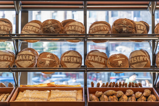 Loaves of bread displayed on bakery shelves.