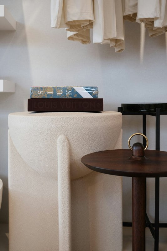 A book with louis vuitton on a pedestal.