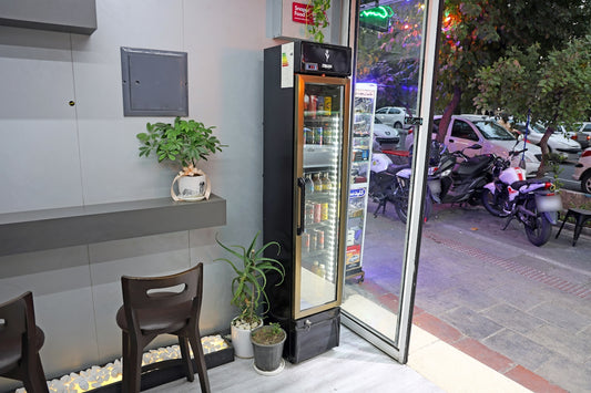 A refrigerator filled with drinks next to a window.