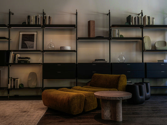 Modern living room with modular shelves and mustard armchair.