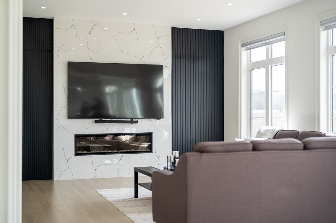 Modern living room with large television over fireplace.