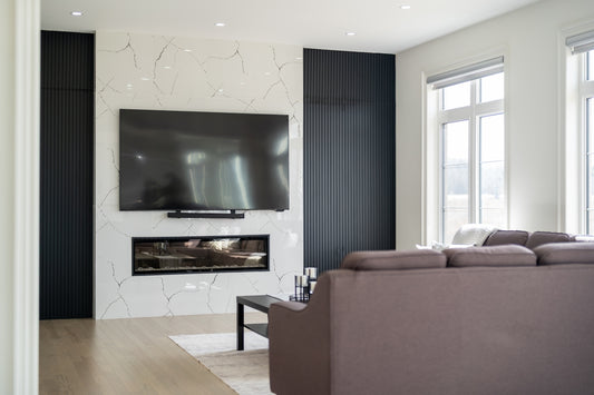 Modern living room with large television over fireplace.