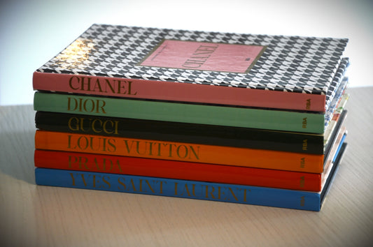 Stack of fashion books with designer names